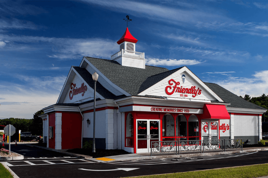 The image features a classic Friendly’s restaurant with its signature white and red exterior, complete with a charming cupola and weather vane. The sign reads, "Creating Memories Since 1935," evoking nostalgia for family dining and ice cream treats.