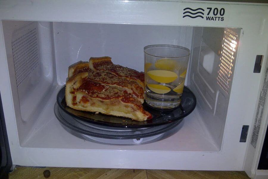 food and a glass of water inside a microwave